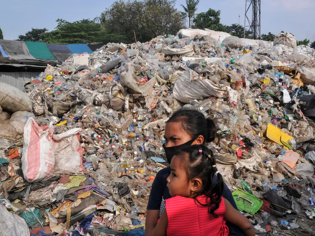 Warga melintas di samping limbah sampah plastik Bantargebang, Bekasi, Jawa Barat, Jum'at (5/6/2020). (ANTARA FOTO/ Fakhri Hermansyah)