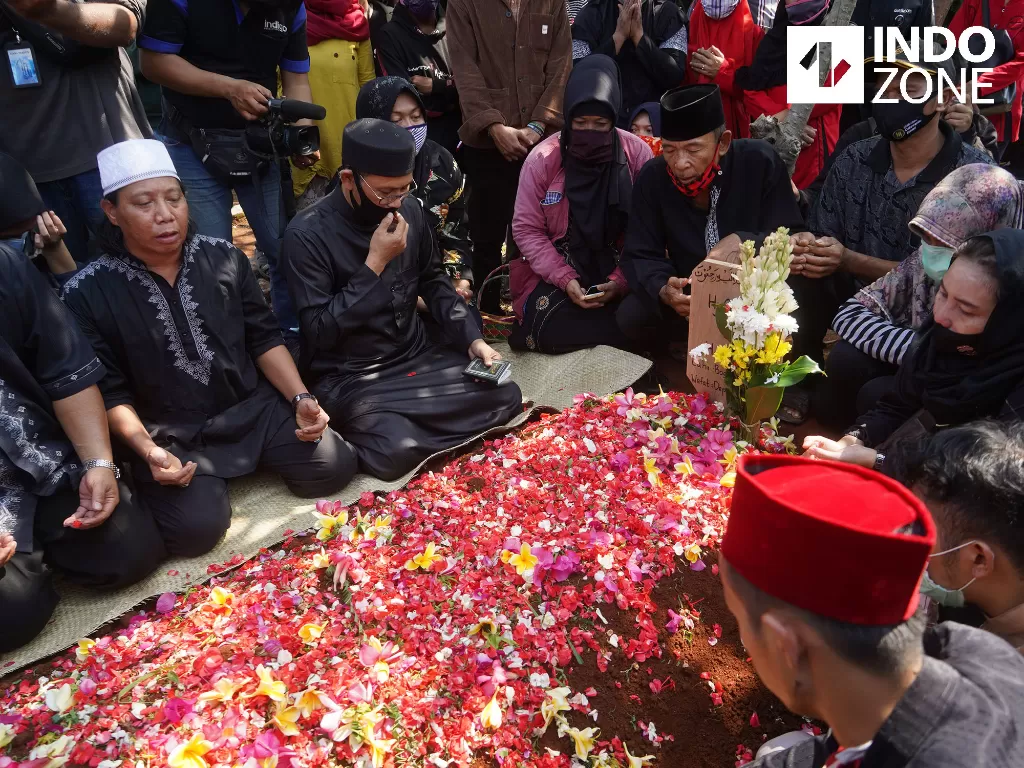Para kerabat dan keluarga berdoa di samping makam pelawak Omas di TPU Cisalak, Depok, Jawa Barat, Jumat (17/7/2020). (INDOZONE/Arya Manggala)