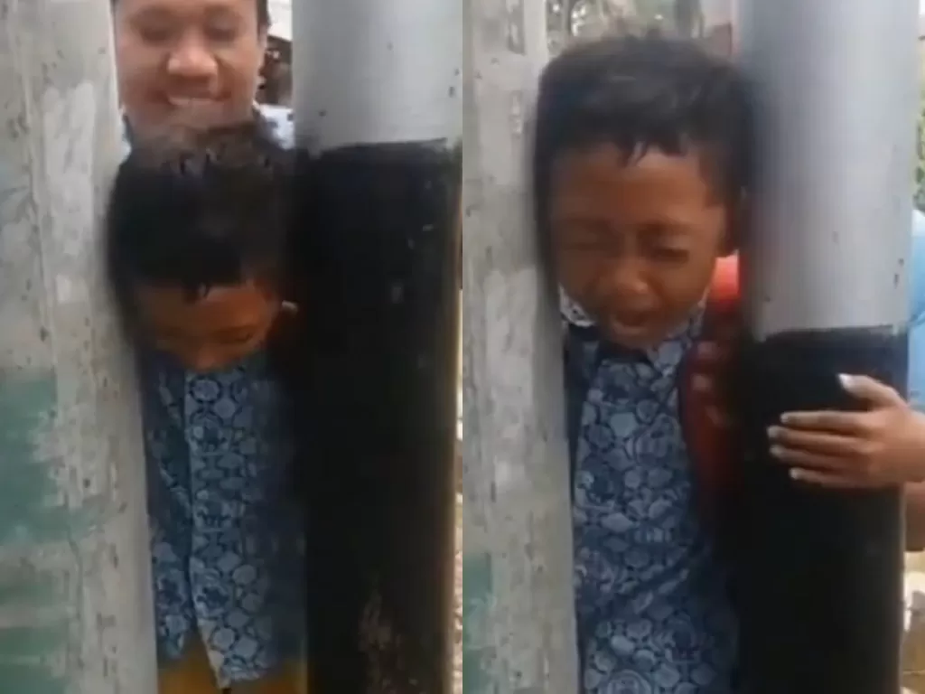 Cuplikan video anak menjerit lantaran kepala tersangkut di antara tiang.