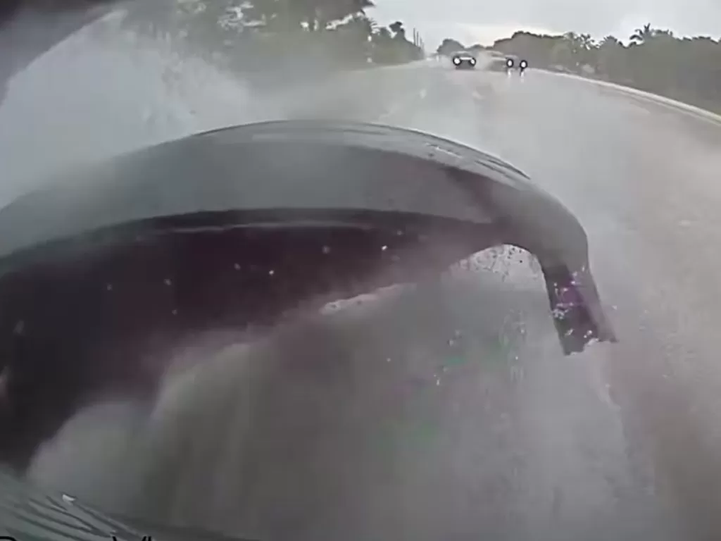 Tampilan bumper belakang Tesla Model 3 yang lepas saat melaju di cuaca hujan deras. (SS/Youtube/Logan Jamal)