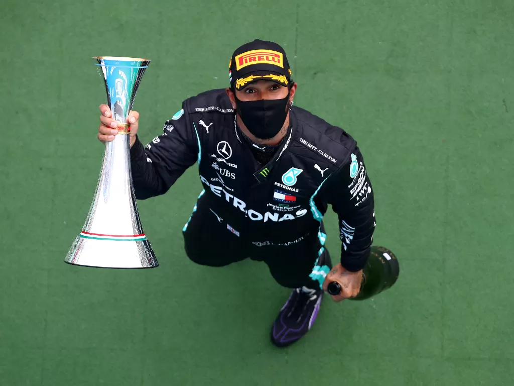  Pembalap Mercedes Lewis Hamilton merayakan kemenangan balapan di podium dengan piala, di Sirkuit Hungaroring, Budapest, Hungaria, 19 Juli 2020. (Mark Thompson/Pool via REUTERS)