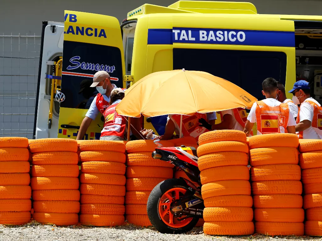 Pembalap Repsol Honda Marc Marquez ditarik ke ambulans setelah mengalami kecelakaan saat balapan di sirkuit Jerez, Spanyol, 19 Juli 2020. (REUTERS/Marcelo Del Pozo)