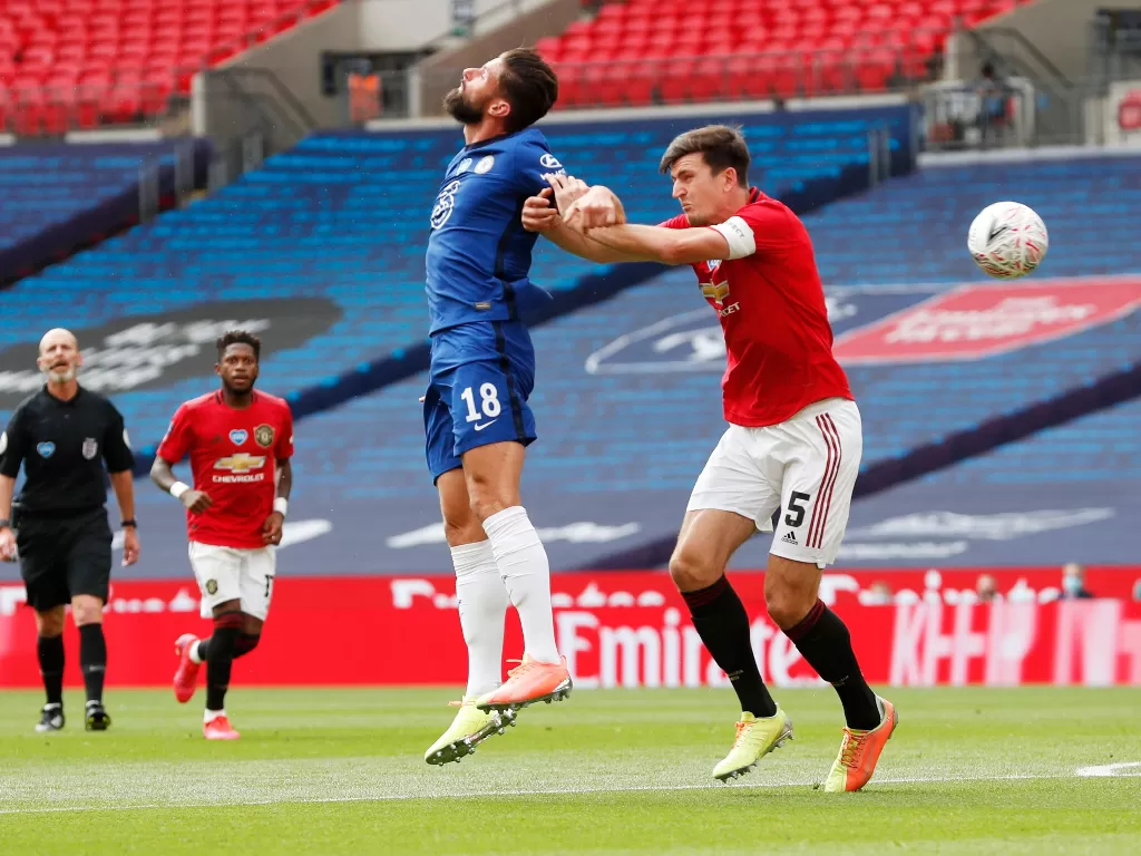 Pemain Chelsea, Oliver Giroud sedang duel udara dengan pemain MU, Harry Maguire. (REUTERS/Alastair Grant)