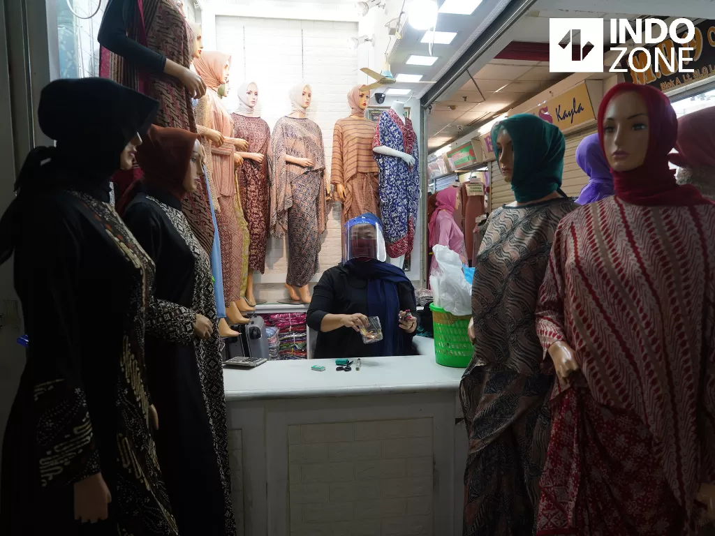  Pedagang memakai masker dan face shield saat merapikan dagangannya di Pasar Tanah Abang Blok A, Jakarta, Senin (15/6/2020). (INDOZONE/Arya Manggala) 