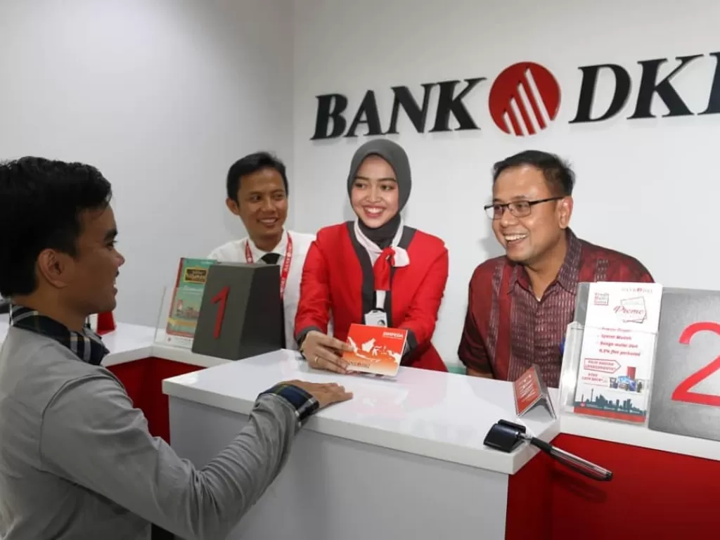 Pemimpin Grup Pengembangan Jaringan Bank DKI, Romy Wijayanto (kanan) berbincang dengan nasabah. (Instagram/@bank.dki)