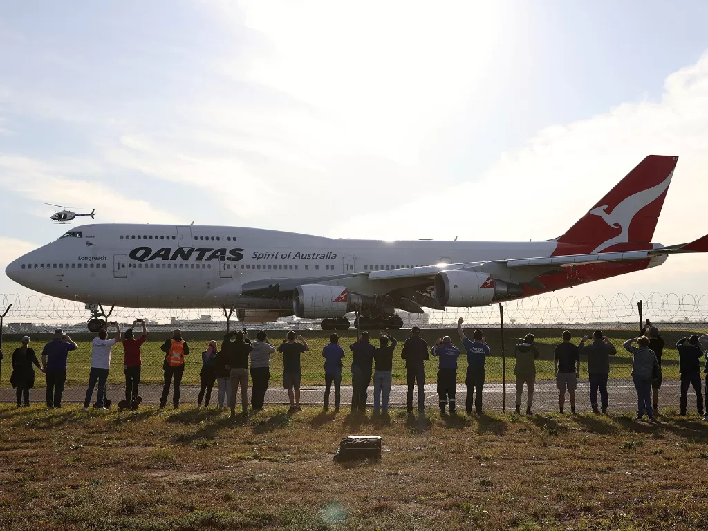 Orang-orang menonton jet Qantas 747 terakhir berangkat dari Bandara Sydney di Sydney, Australia, ketika Qantas pensiunkan pesawat Boeing 747 yang tersisa lebih awal karena wabah penyakit coronavirus (COVID-19), 22 Juli 2020. (REUTERS/Loren Elliott)
