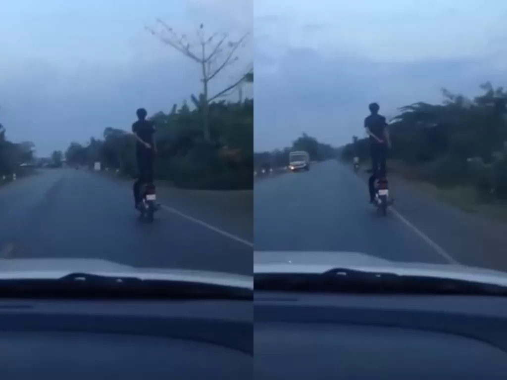 Seorang pria berdiri di atas motor yang sedang melaju. (Screenshot)