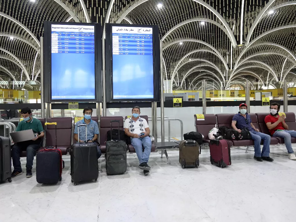 Para penumpang yang mengenakan masker menunggu penerbangan di Bandara Internasional Baghdad di Baghdad, Irak, pada 23 Juli 2020. (Xinhua)