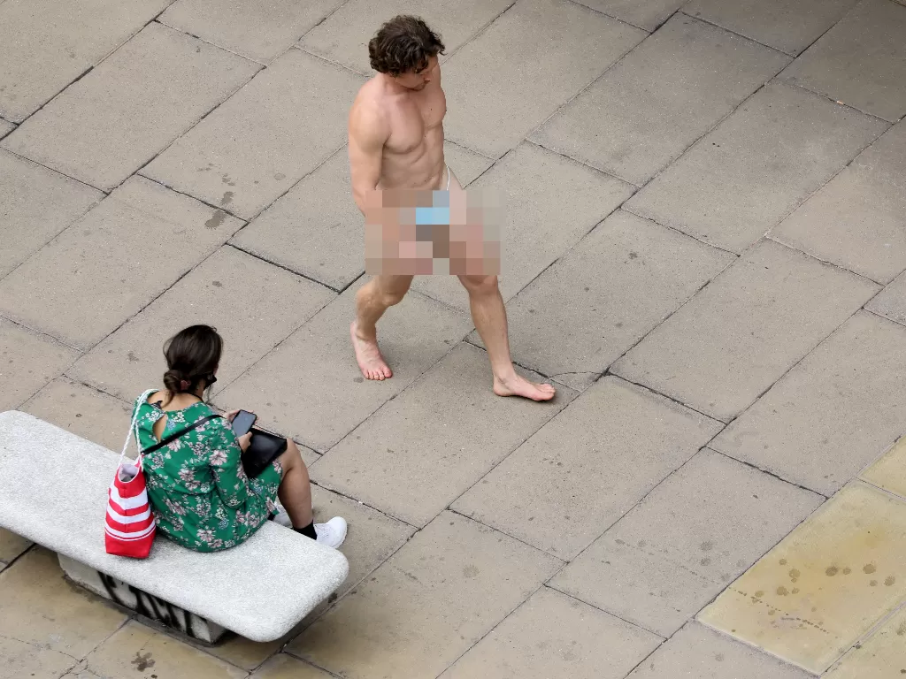 Seorang pria berjalan telanjang di tempat umum. (REUTERS/Simon Dawson)