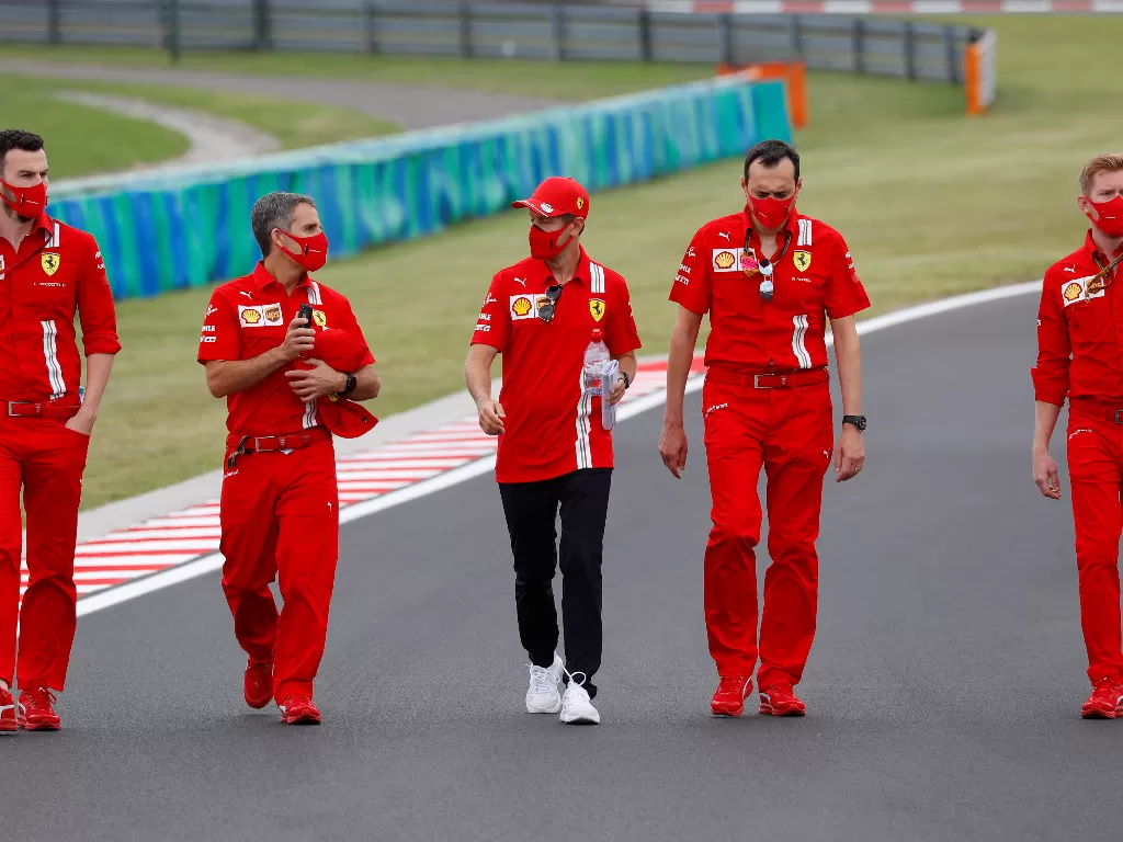 Sebastian Vettel dengan kru Ferrari. (REUTERS/LEONHARD FOEGER)
