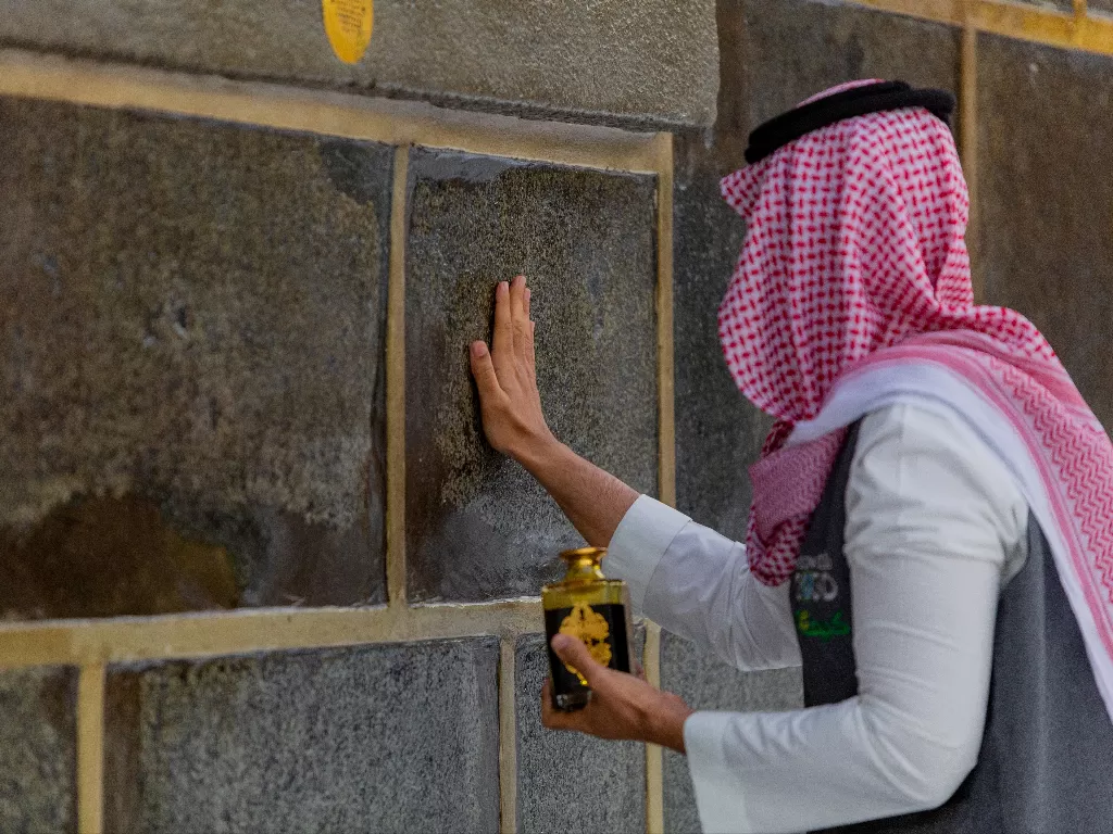 Seorang petugas memberi pengharum dinding ka'bah di Masjidil Haram pada musim ibadah haji di tengah wabah virus corona (COVID-19), Mekah, Arab Saudi (26/7/2020). (Photo/REUTERS)