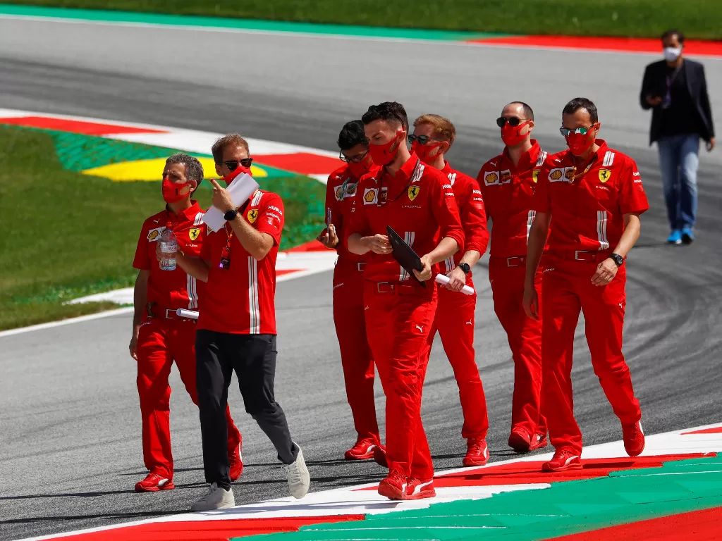 Pembalap Ferrari, Sebastian Vettel dengan kru Ferrari. (REUTERS/Leonhard Foeger)