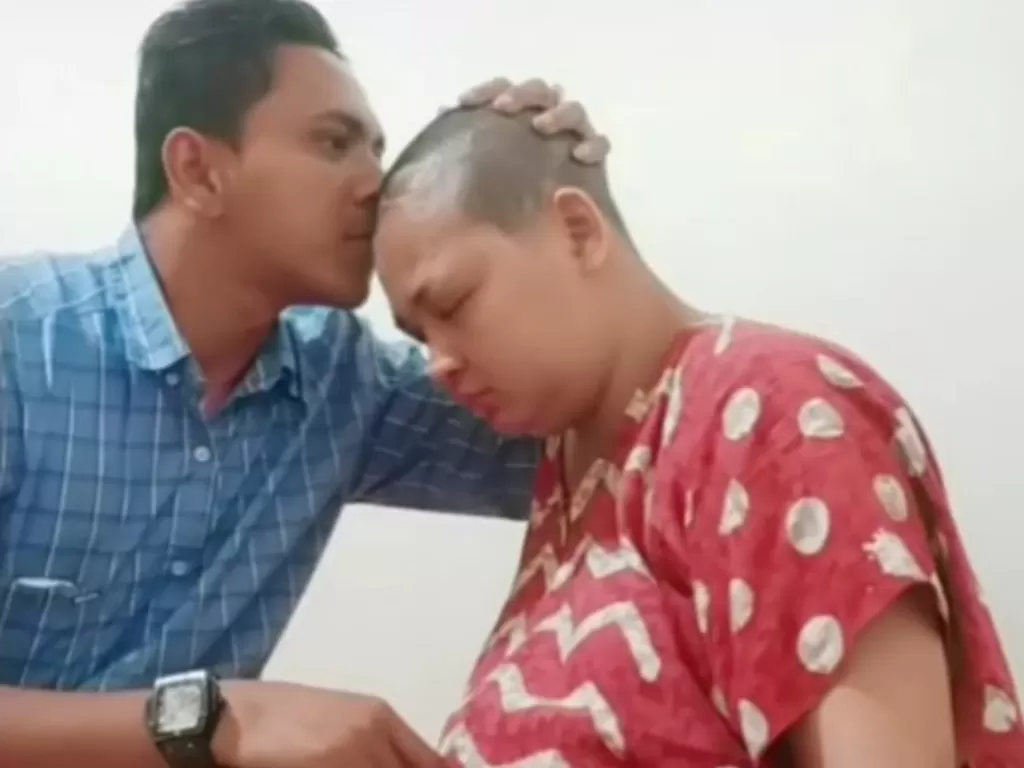 T Rezal Saputra mencium istrinya yang terkena kanker otak. (Foto: Istimewa)