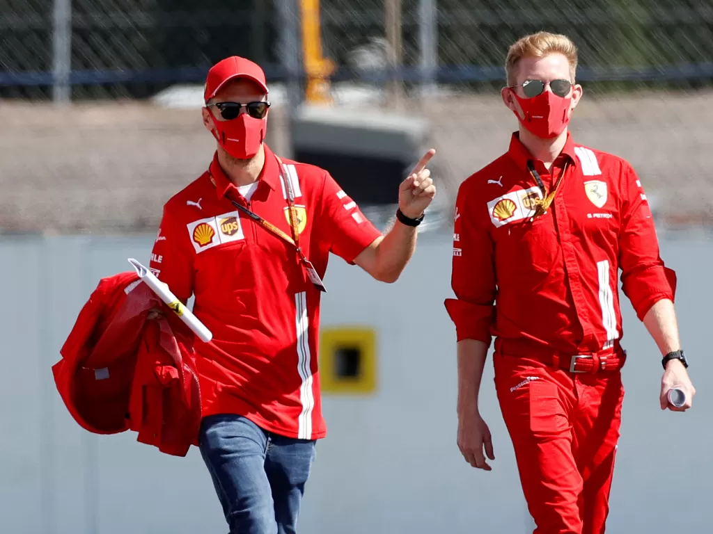 Sebastian Vettel dengan kru Ferrari. (REUTERS/ANDREW BOYERS)