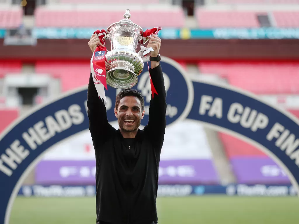 Pelatih Arsenal, Mikel Arteta mengangkat trofi Piala FA. (REUTERS/Catherine Ivill)