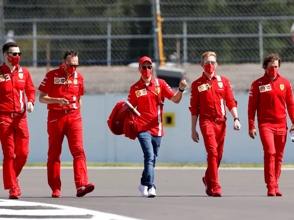 Sebastian Vettel dengan kru Ferrari. (REUTERS/ANDREW BOYERS)