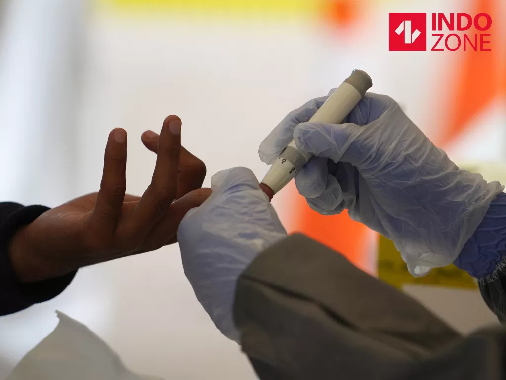 Petugas medis mengambil sampel darah jurnalis saat Rapid Test Covid-19 secara Drive-Thru di Halaman Gedung Kementerian Komunikasi dan Informatika, Jakarta, Rabu (8/4/2020). (INDOZONE/Febio Hernanto)