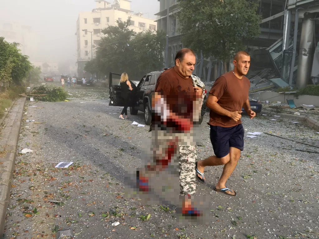 Pria terluka berlarian pascaledakan di Lebanon. (REUTERS/Mohamed Azakir)