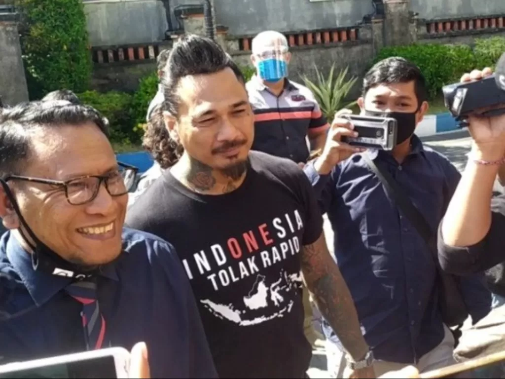 Jerinx SID bersama pengacaranya saat masuk ke dalam Kantor Ditreskrimsus Polda Bali, Kamis (6/8/2020). (Photo/Antara/Ayu Khania Pranisitha) 