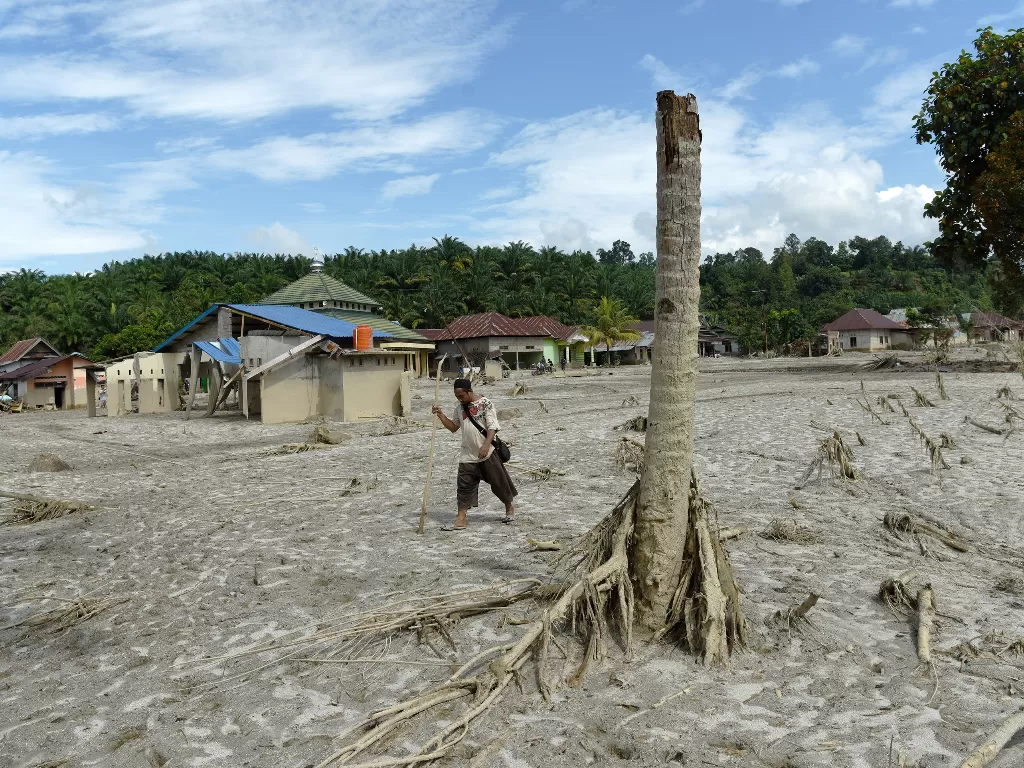 Warga melintas di dekat rumah yang rusak akibat diterjang banjir bandang di Desa Petambua Masamba, kabupaten Luwu Utara, Sulawesi Selatan Rabu (22/07/2020). (ANTARA/Yusran Uccang)