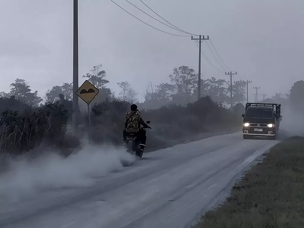 Sejumlah kendaraan melintas di jalan yang dipenuhi debu vulkanik pascaerupsi Gunung Sinabung, di Desa Sigarang-garang, Karo, Sumatera Utara. (ANTARA/Sastrawan Ginting)
