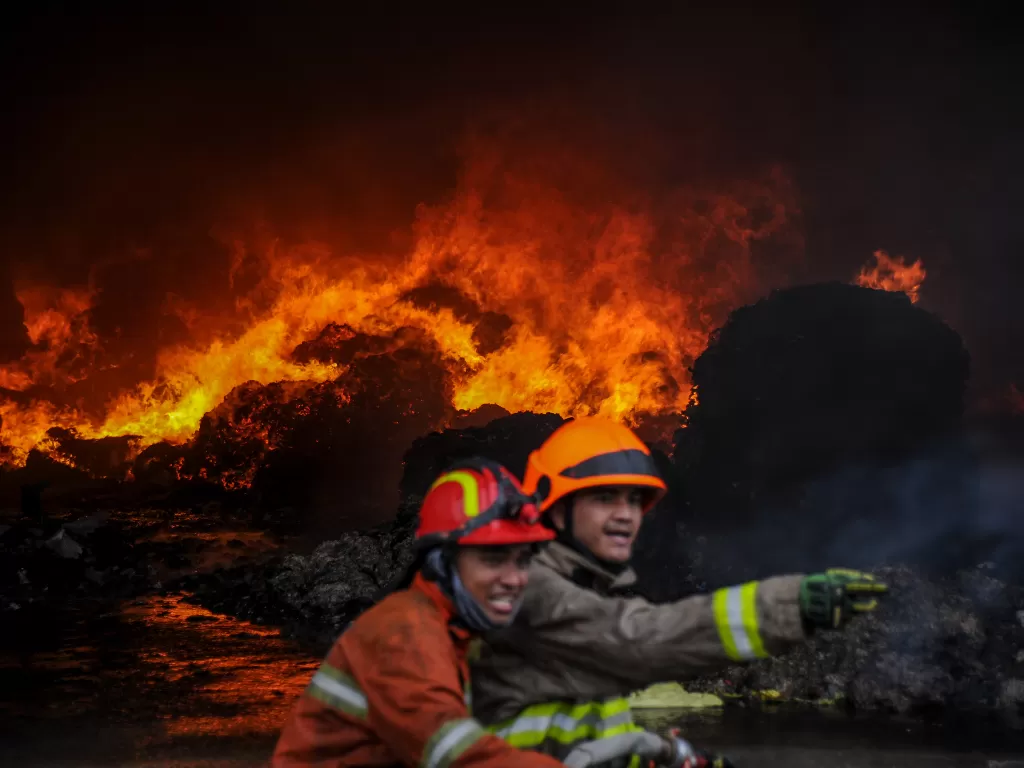 Petugas pemadam kebakaran berusaha memadamkan api yang membakar salah satu gudang pabrik kapas di Cipadung, Bandung, Jawa Barat, Selasa (11/8/2020). ANTARA FOTO/Raisan Al Farisi