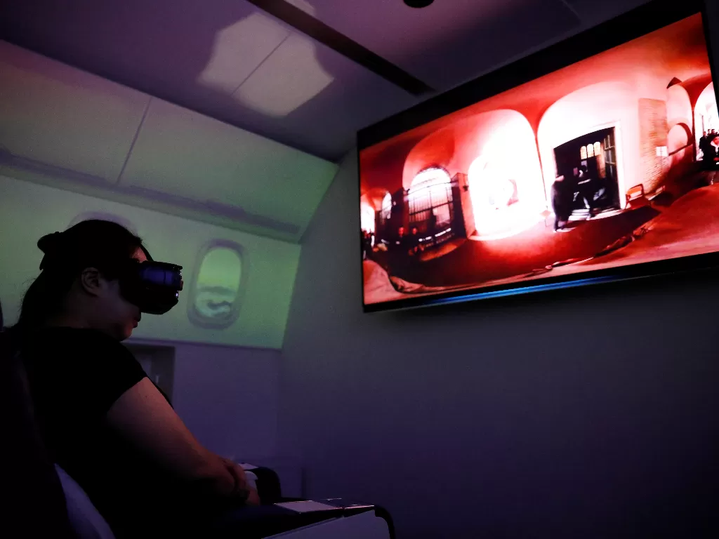 Seorang wanita di kursi penerbangan menggunakan perangkat virtual reality (VR) di First Airlines, yang memberikan pengalaman penerbangan VR (REUTERS/KIM KYUNG-HOON)