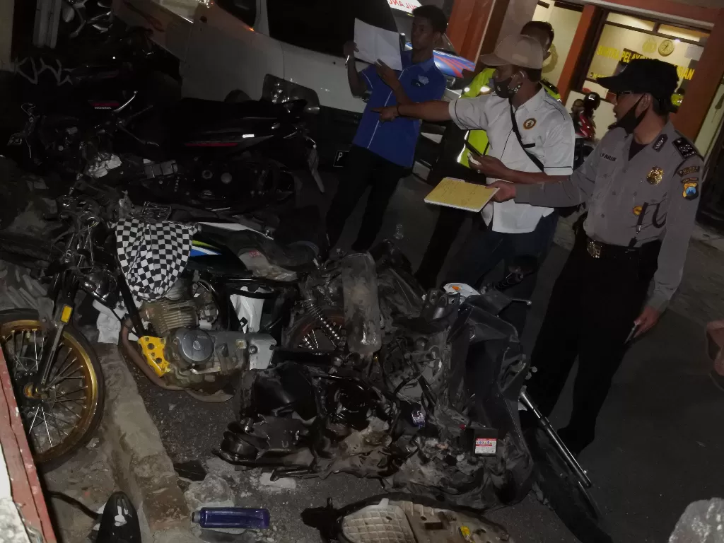 Polisi mengidentifikasi sepeda motor yang terlibat kecelakaan beruntun di jalan nasional Jember-Banyuwangi Desa Sempolan, Silo, Jember, Jawa Timur, Kamis (13/8/2020). ANTARA FOTO/Seno