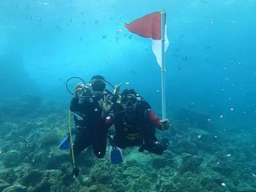 Personel Ditpolairud Polda Aceh mengibarkan bendera Merah Putih di dasar laut nol kilometer, Pulau Weh, Sabang, Kamis (13/8/2020). (ANTARA/HO/Bidang Humas Polda Aceh)