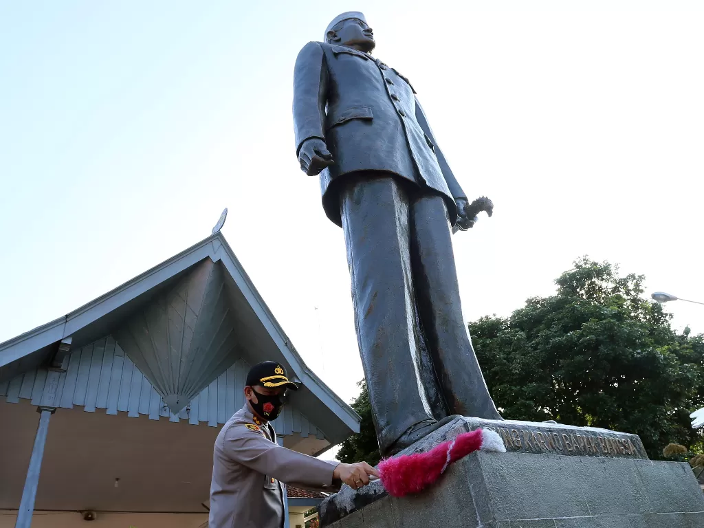 Kapolres Blitar Kota AKBP Leonard M. Sinambela membersihkan patung presiden Soekarno di Muesum Istana Gebang Blitar, Jawa Timur, Sabtu (15/8/2020). ANTARA FOTO/Irfan Anshori