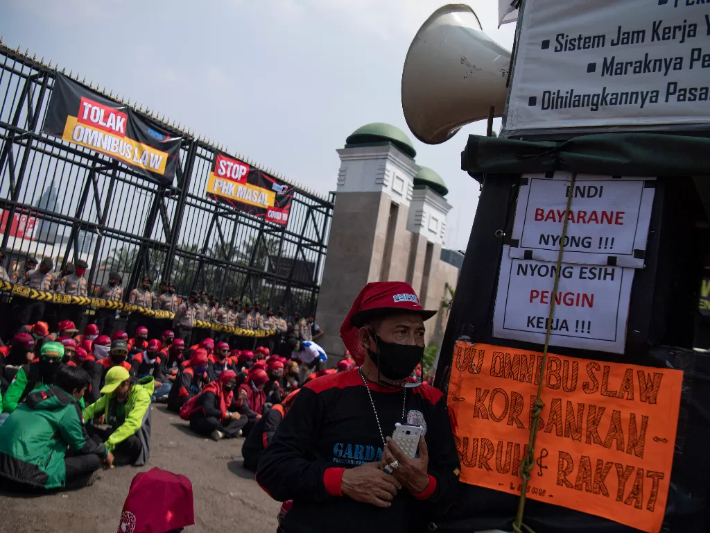 Sejumlah buruh melakukan aksi unjuk rasa di depan gedung DPR, Senayan, Jakarta, Rabu (29/7/2020). Mereka menuntut DPR untuk menghentikan pembahasan Omnibus Law RUU Cipta Kerja. (ANTARA FOTO/Sigid Kurniawan)