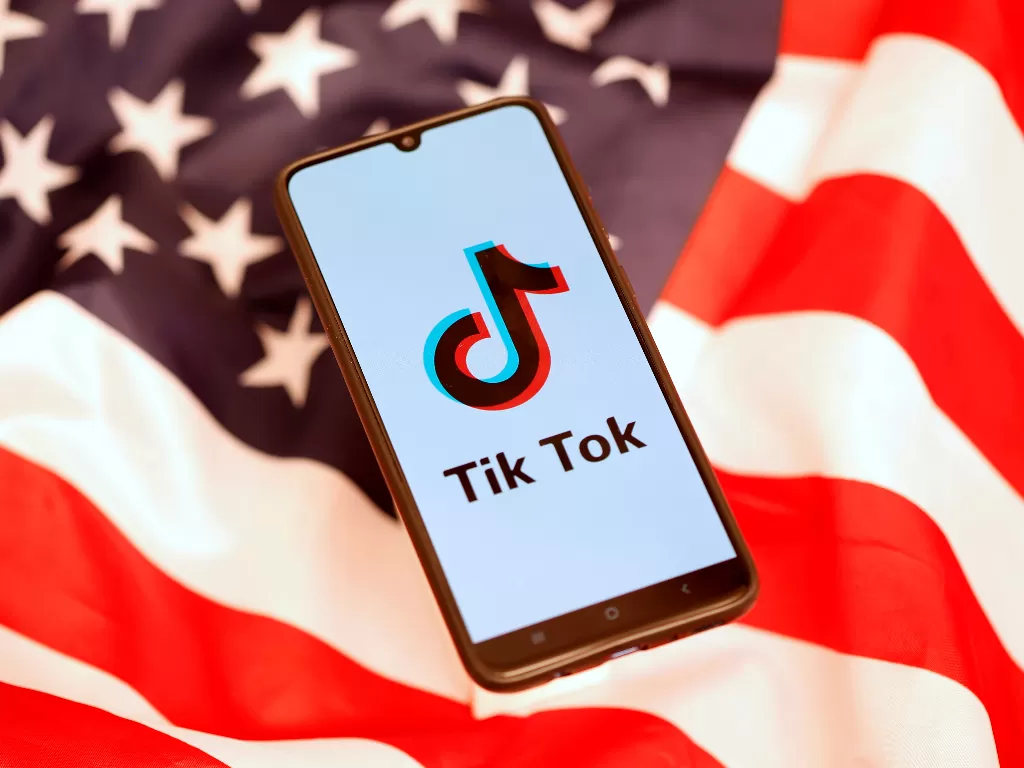Ilustrasi logo TikTok di atas bendera Amerika Serikat (photo/REUTERS/Dado Ruvic)