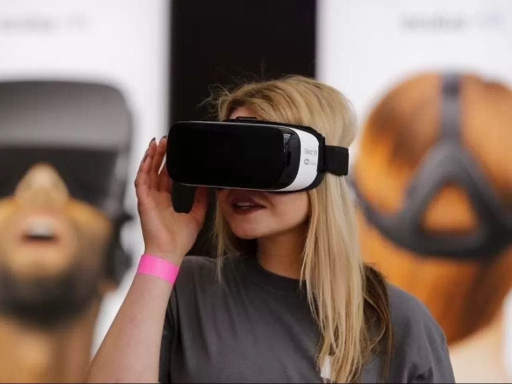 Seorang wanita sedang menggunakan perangkat VR Oculus (photo/REUTERS/Fabrizio Bensch)