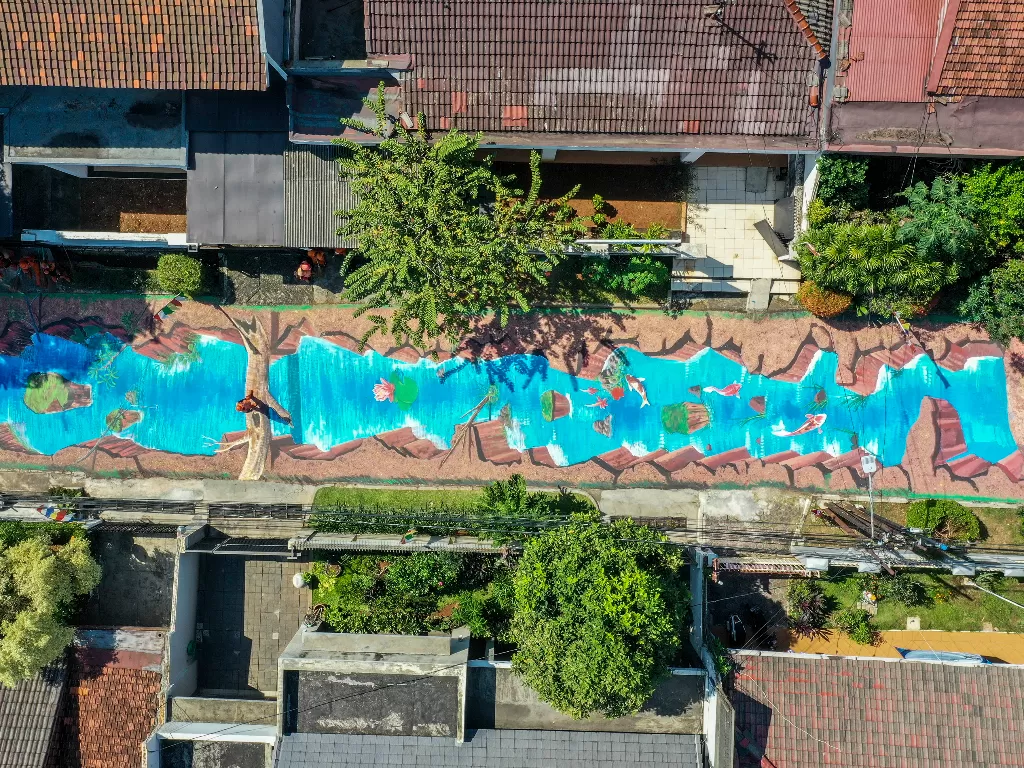 Foto areal petugas kebersihan membersihkan jalan yang telah dilukis mural di Jalan Keuangan, Cilandak, Jakarta, Selasa (25/8/2020). ANTARA FOTO/Galih Pradipta