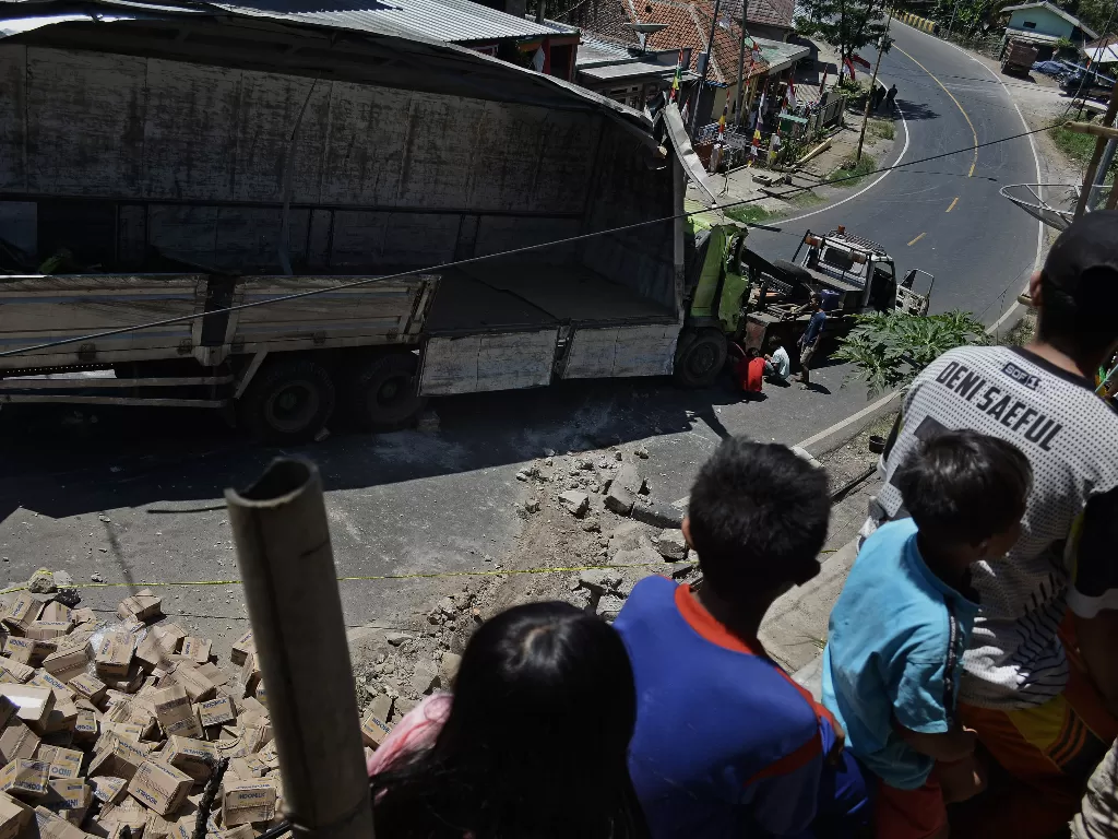 Warga melihat proses evakuasi truk pengangkut susu kemasan yang terguling di Nagreg, Kabupaten Bandung, Jawa Barat, Selasa (25/8/2020). ANTARA FOTO/Candra Yanuarsyah