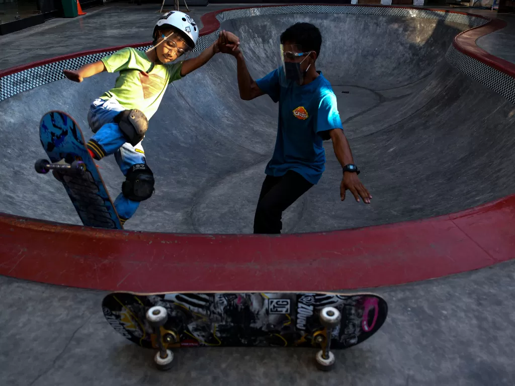 Seorang instruktur memegangi anak didiknya saat berlatih skateboard di Crooz Shophouse, Jakarta, Jumat (28/8/2020). ANTARA FOTO/M Risyal Hidayat