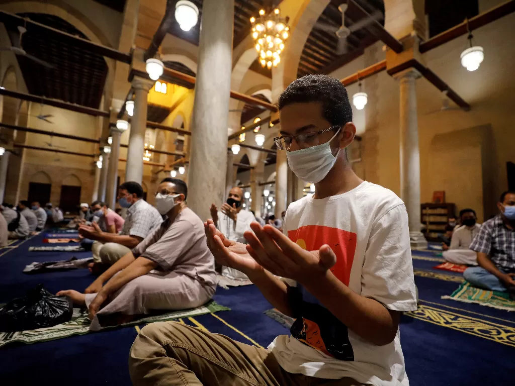 Seorang Muslim yang mengenakan masker pelindung berdoa di dalam masjid Al-Azhar selama salat Jumat pertama (REUTERS/MOHAMED ABD EL GHANY)