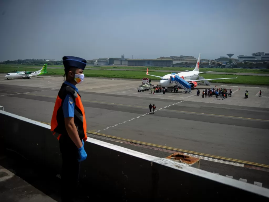 Petugas berjaga pesawat Boeing 737 milik maskapai Lion Air mendarat di Bandara Husein Sastranegara, Bandung, Jawa Barat, Kamis (20/8/2020). (ANTARA FOTO/Raisan Al Farisi)