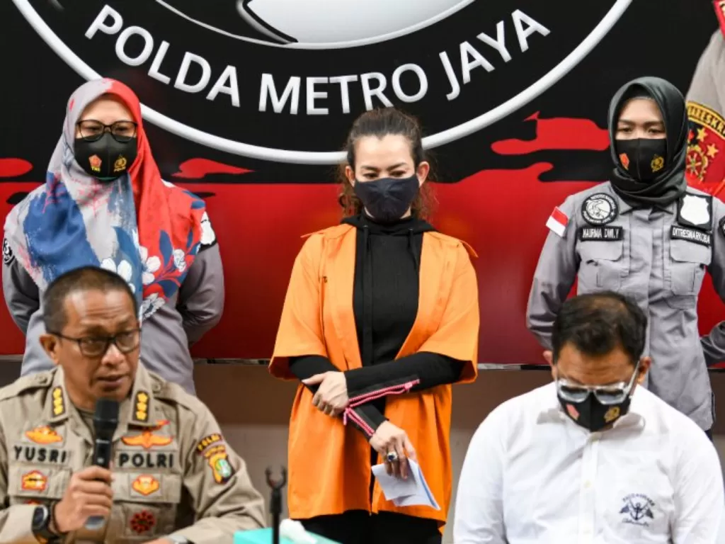 Kabid Humas Polda Metro Jaya Kombes Pol Yusri Yunus (kiri duduk) menunjukkan penyanyi Reza Artamevia (tengah) saat rilis kasus pengungkapan tindak pidana narkotika di Polda Metro Jaya, Jakarta, Minggu (6/9). (ANTARA FOTO/M Risyal Hidayat)