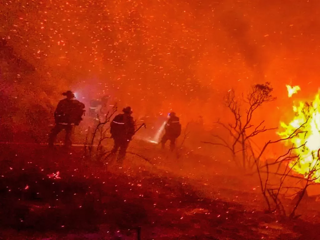 Petugas pemadam kebakaran bekerja untuk memadamkan api di Alpine, California (REUTERS/Steve Russo)