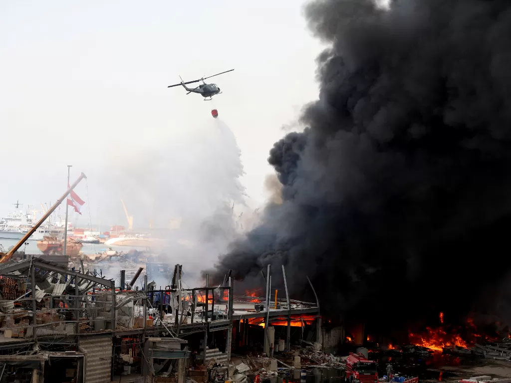 Sebuah helikopter mencoba memadamkan api yang terjadi di area pelabuhan Beirut, Lebanon (REUTERS/Mohamed Azakir)