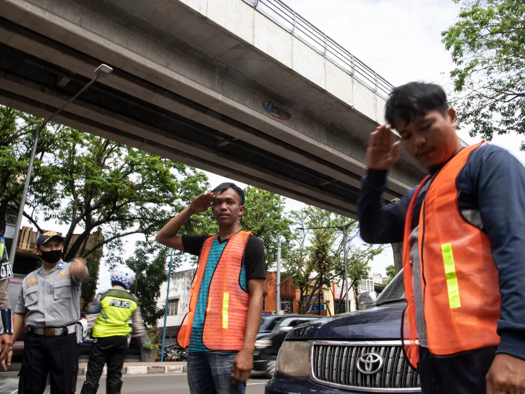 Satgas gabungan memberi hukuman kepada warga yang tidak memakai masker di Jalan Jenderal Sudirman, Palembang (ANTARA FOTO/Nova Wahyudi)