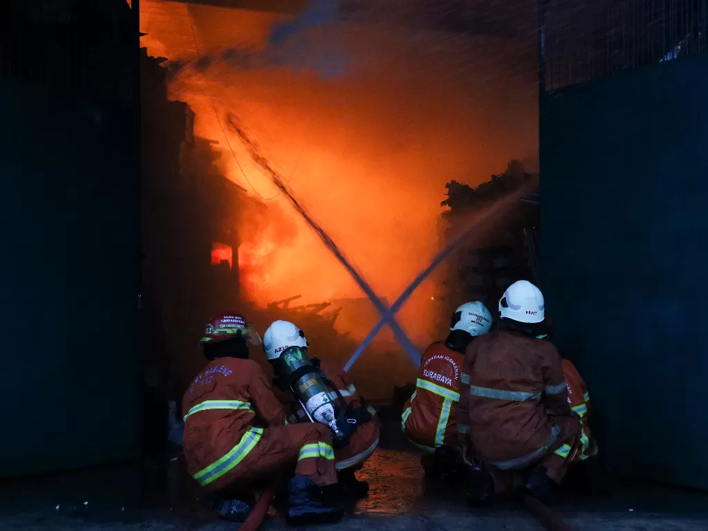 Petugas Dinas Pemadam Kebakaran Kota Surabaya memadamkan gudang yang terbakar di Jalan Niaga Tambang, Surabaya, Jawa Timur, Kamis (17/9/2020). ANTARA FOTO/Didik Suhartono