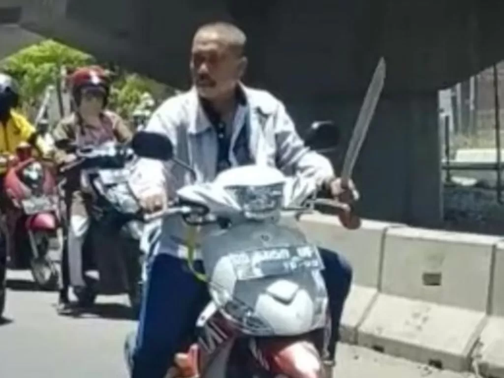 Cuplikan video Daeng Ngalle saat berkendara sembari menenteng sebilah parang hingga viral di media sosial. (istimewa)
