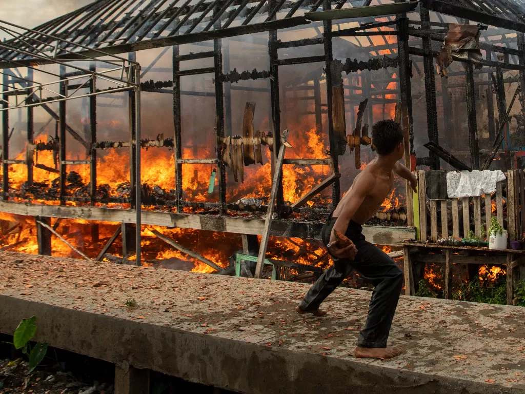 Warga berusaha memadamkan api yang membakar sejumlah bangunan rumah di lorong Pahlawan 35 ilir (ANTARA FOTO/Nova Wahyudi)