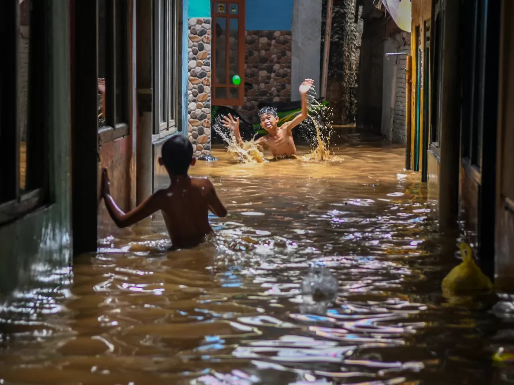 Warga bermain ketika banjir di Kebon Pala, Jatinegara, Selasa (22/9/2020). ANTARA FOTO/Galih Pradipta