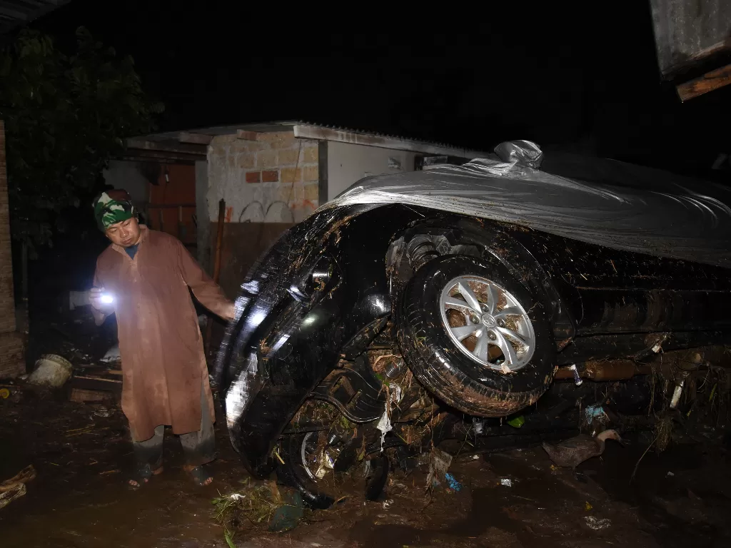 Petugas memeriksa kondisi kendaraan yang terbawa arus banjir bandang di Desa Mekarsari, Kecamatan Cicurug, Kabupaten Sukabumi, Jawa Barat (ANTARA FOTO/Iman Firmansyah)