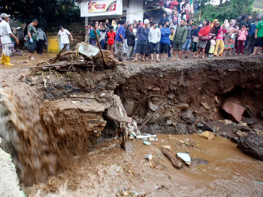 Warga melihat jalanan yang rusak pasca banjir bandang di Kampung Cibuntu (ANTARA FOTO/Yulius Satria Wijaya)