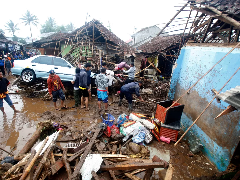 Warga meihat mobil yang rusak terbawa arus banjir bandang di Kampung Cibuntu, Desa Pasawahan, Kecamatan Cicurug, Sukabumi, Jawa Barat, Selasa (22/9/2020).  (Foto: ANTARA/Yulius Satria Wijaya)