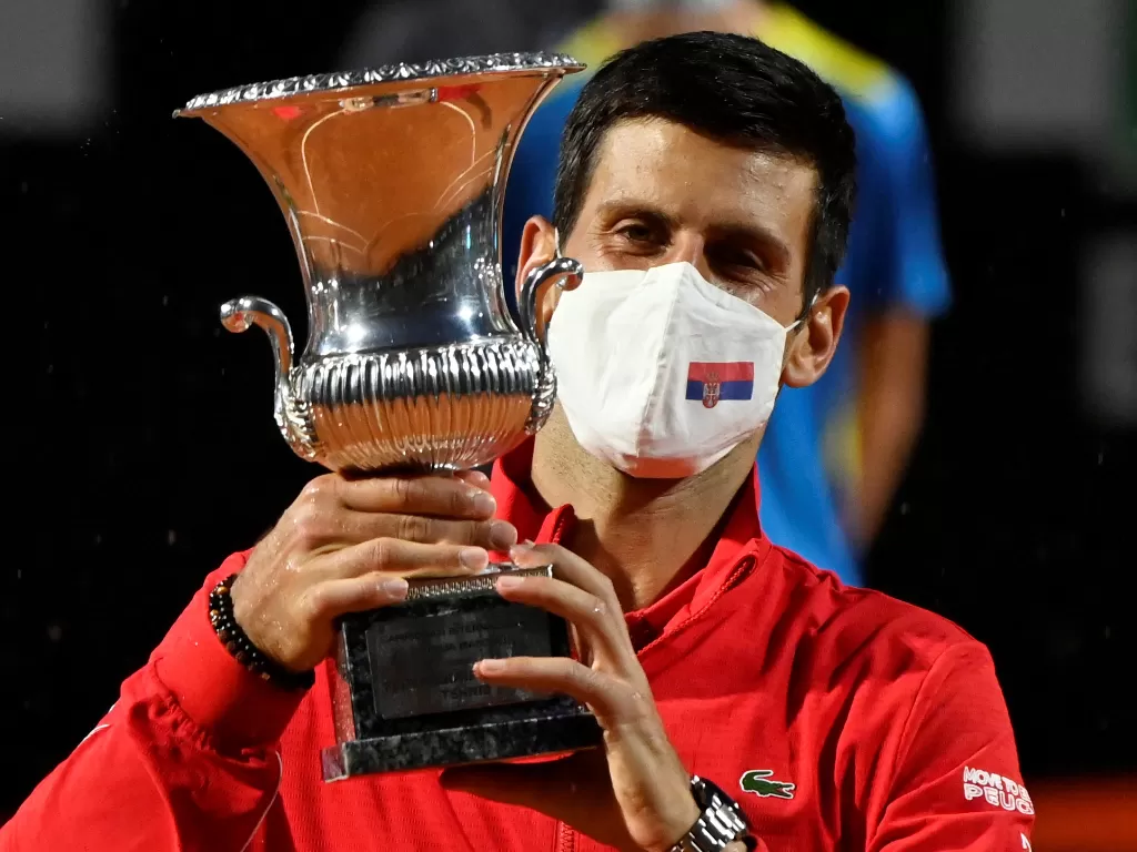 Novak Djokovic dari Serbia merayakan dengan trofi setelah memenangkan final melawan Diego Schwartzman dari Argentina (REUTERS/Riccardo Antimiani)